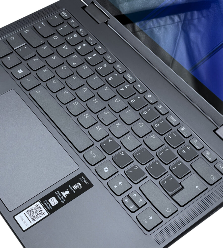 Lenovo Yoga 7 2w1 14AHP9 – ergonomiczna klawiatura. Lenovo Yoga 7 2w1 14AHP9 zbliżenie na klawiaturę, touchpad i przestrzeń roboczą.